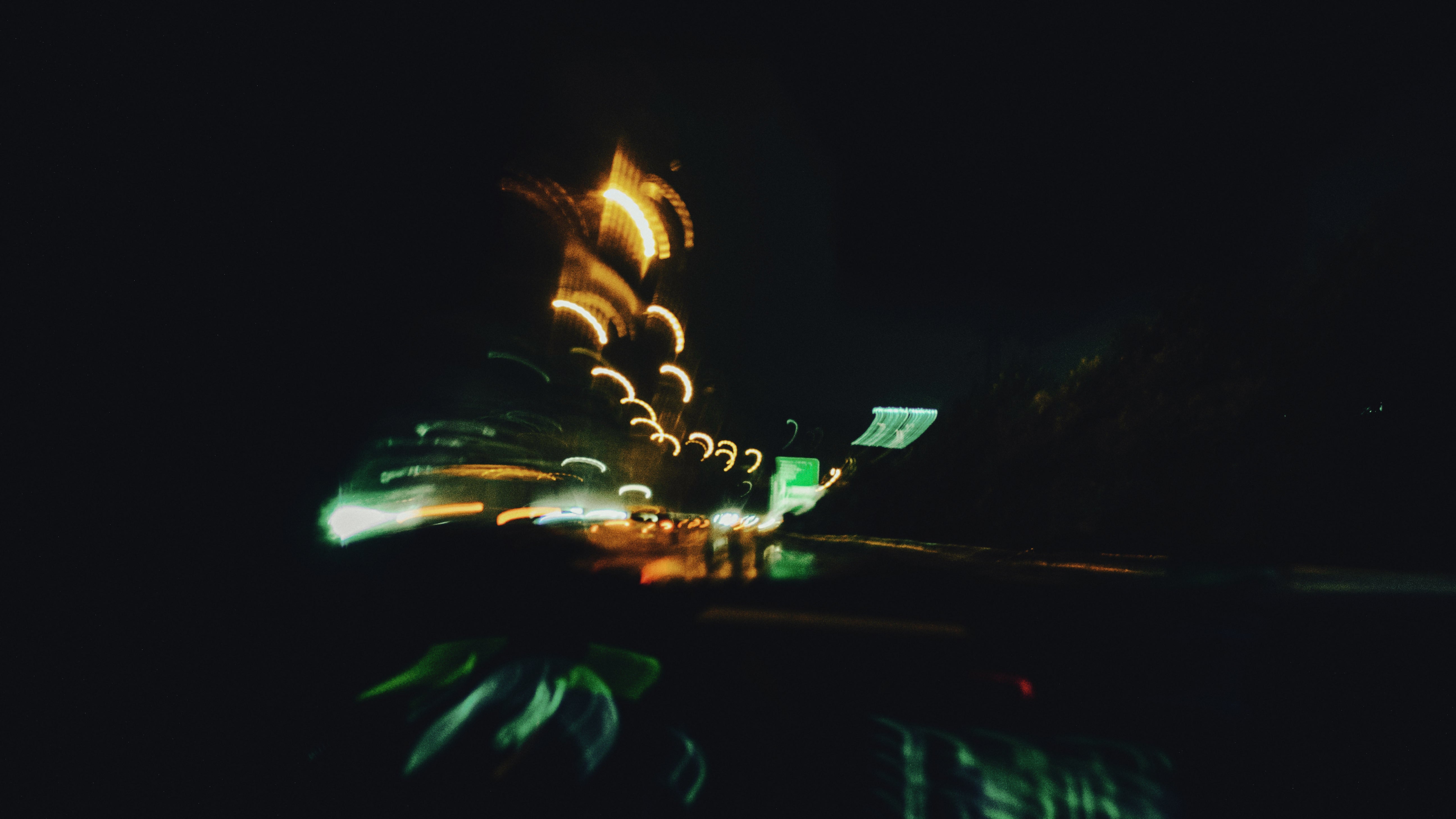 夜の高速道路を走る車内から見た、光が滲み揺れる景色。思考が活発になり、頭の中が止まらない夜の状態を象徴するイメージ